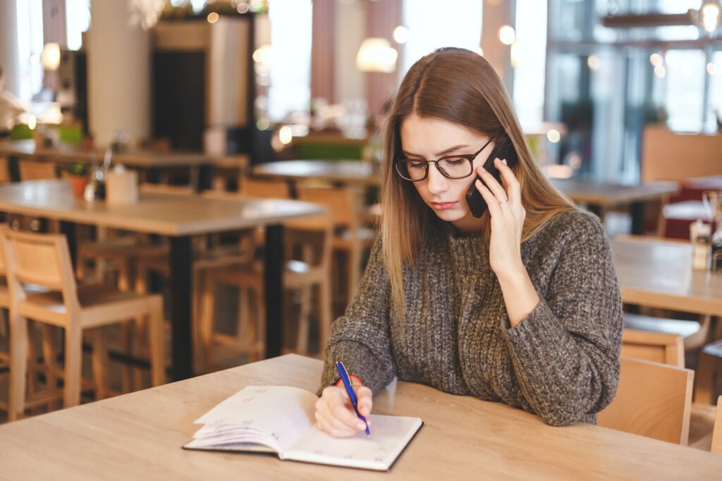 Young woman accountant talking on cell phone